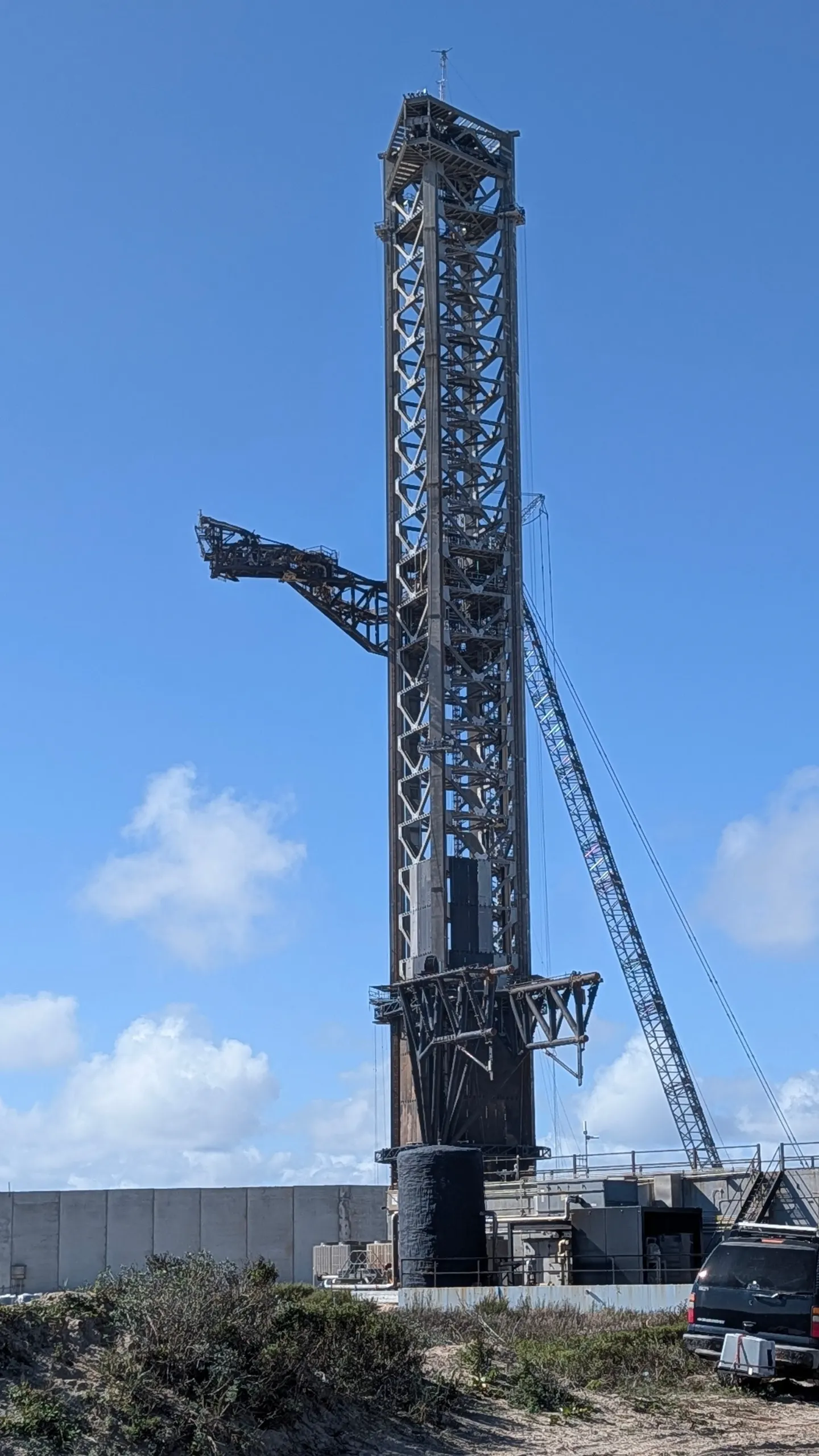 SpaceX Starbase orbital launch tower against a blue sky, chopstick arm extended