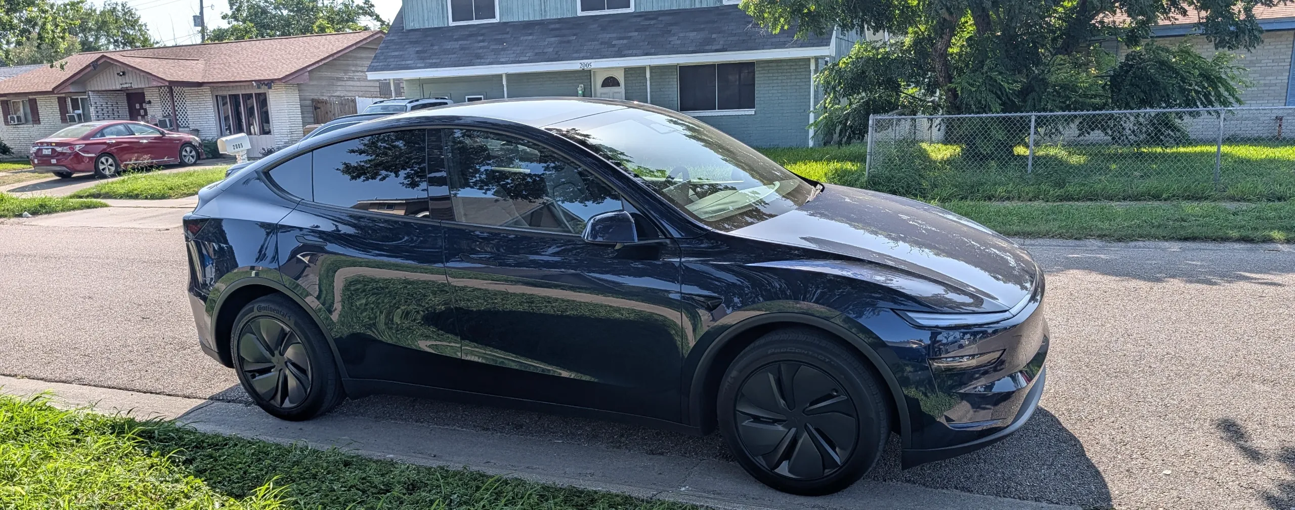 Roy's Marine Blue Tesla Model Y Premium RWD parked on a residential street